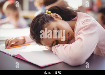 Müde Schulmädchen schlafen im Unterricht in der Schule Stockfoto