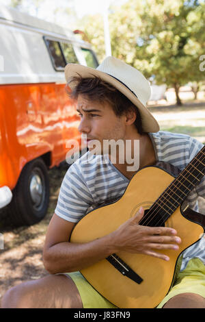 Junger Mann spielt Gitarre im park Stockfoto