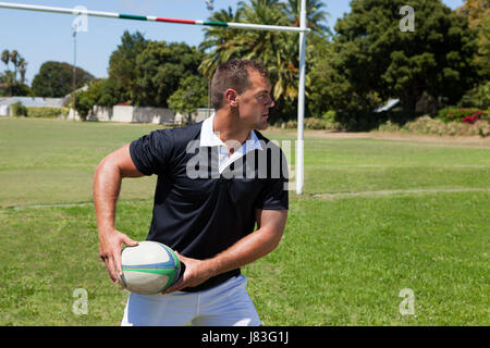 Spieler werfen Rugby-Ball im stehen durch die Torpfosten auf Feld Stockfoto