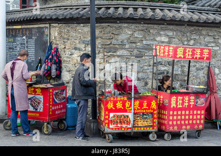 Dali, China - April 19,2017: Street View der Dali Altstadt in Yunnan, China. Leuten gesehen, Kauf von Lebensmitteln aus der Nahrung neben der Straße blockieren kann. Stockfoto