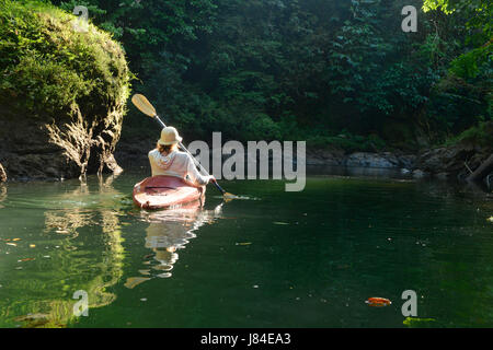 Eine Frau Kajaks durch den Agujitas-Fluss in Drake Bay, Costa Rica. Stockfoto