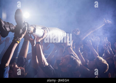 Crowdsurfing bei einem Konzert in Nachtclub Stockfoto