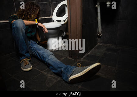 Mann, Erbrechen am Toilettenbecken im Waschraum Stockfoto