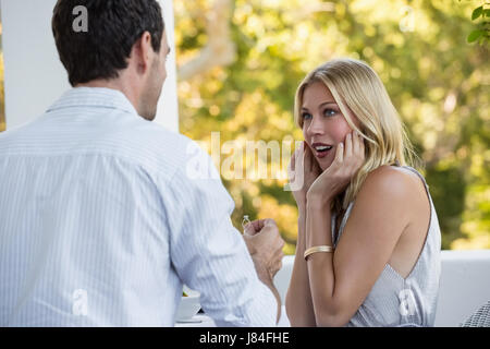 Überrascht Frau Blick auf Menschen, die ihr im Restaurant vorschlagen Stockfoto