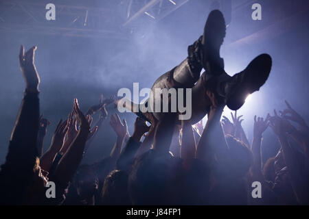 Crowdsurfing bei einem Konzert in Nachtclub Stockfoto