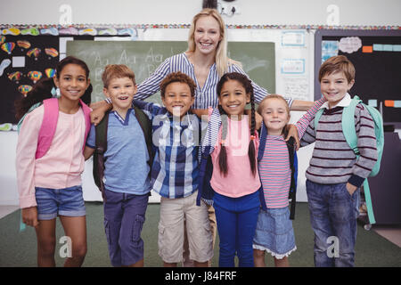 Glückliche Lehrer mit Schüler im Klassenzimmer in der Schule Stockfoto