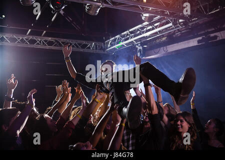 Crowdsurfing bei einem Konzert in Nachtclub Stockfoto