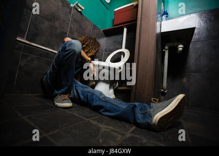 Mann, Erbrechen am Toilettenbecken im Waschraum Stockfoto