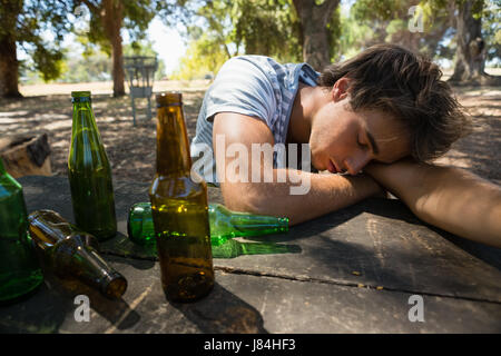 Einsamer betrunkenen Mann schlafen auf dem Tisch im park Stockfoto