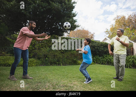 Lächeln mehr-Generationen-Familie zusammen mit Fußball im Park zu spielen Stockfoto