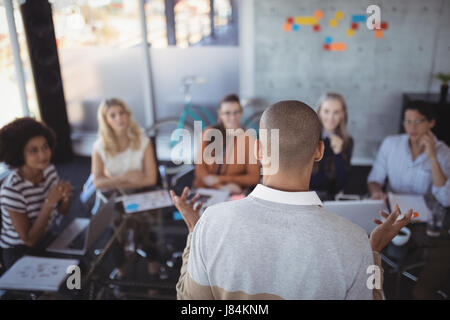Rückansicht des Kaufmanns Strategien erläutert, Kolleginnen und Kollegen im Kreativbüro Stockfoto