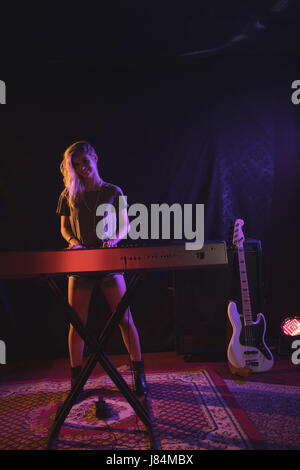 Porträt von lächelnden Musikerin Klavierspiel in Nachtclub Stockfoto