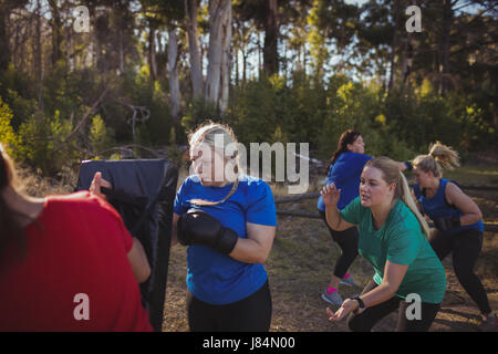 Frau üben Boxen in das Boot Camp an einem sonnigen Tag Stockfoto