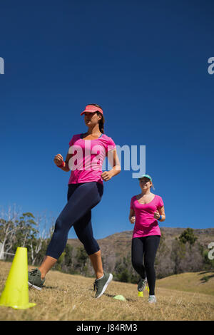 Zwei Frauen laufen durch Zapfen in das Boot Camp an einem sonnigen Tag Stockfoto