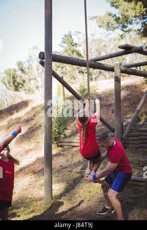 Trainer unterrichten ein Kind in das Boot Camp an einem sonnigen Tag Stockfoto