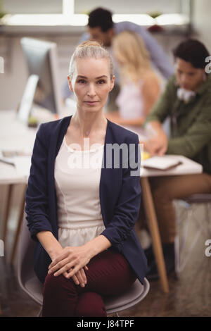 Porträt von Ernst Geschäftsfrau sitzend auf Stuhl bei Kreativbüro Stockfoto