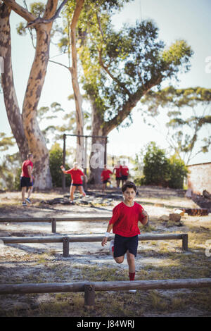 Trainer unterrichten Kinder beim Hindernis-Parcours-Training im Boot camp Stockfoto