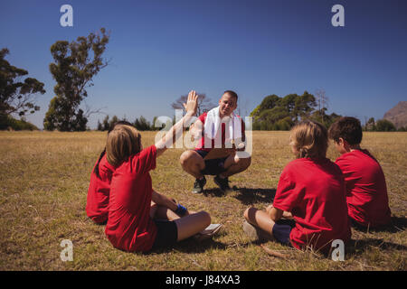 Trainer unterrichten Kinder in das Boot Camp an einem sonnigen Tag Stockfoto