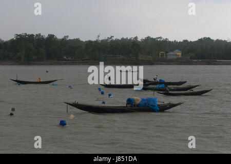 Fischer Angeln am Fluss Poshur mit einem Holzboot am Mongla. Bagerhat, Bangladesch. Stockfoto