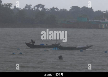 Fischer Angeln am Fluss Poshur mit einem Holzboot am Mongla. Bagerhat, Bangladesch. Stockfoto