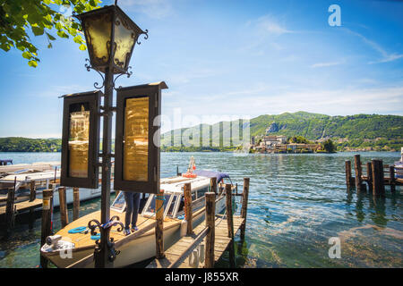 Orta San Giulio, Italien, 21. Mai 2017 - The Orta See Boot Docks und Laternenpfahl mit Zeitplänen zur Insel San Giulio Stockfoto