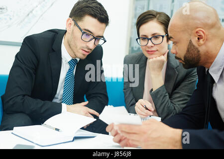 Porträt von drei Geschäftsleute sitzen am runden Tisch treffen, Arbeiten diskutieren Stockfoto
