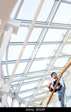 Junge Businesman gelehnt Geländer im modernen Office center Stockfoto
