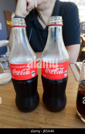 Zwei klassische Coca-Cola-Flaschen serviert Ihnen ein Restaurant, New-South.Wales, NSW, Australien Stockfoto