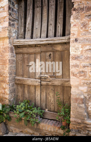 Seitenansicht des alten Holztür in das alte Steinhaus dekoriert mit Pflanzen in Töpfen. Als ein Vintage Foto bearbeitet. Stockfoto