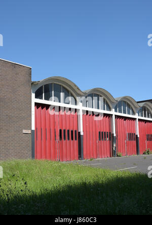 Stillgelegte Feuerwache mit krummlinigen Dach, fünf Buchten mit Glasfensterscheiben und roten Klapptüren, Bury lancashire uk Stockfoto