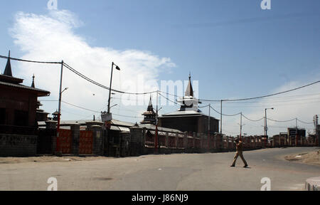 Srinagar, Kaschmir. 28. Mai 2017. Ein indischer Polizist patrouilliert verlassene Straßen da Regierungstruppen strenge Ausgangssperre in vielen Teilen von Kaschmir durchgesetzt haben. Ein Zivilist wurde getötet und Dutzende weitere wurden verletzt, als massive Anti-Indien Proteste und Auseinandersetzungen folgten die Morde in Kaschmir am Samstag. Acht Kämpfer wurden von Sicherheitskräften erschossen. Bildnachweis: Sofi Suhail/Alamy Live-Nachrichten Stockfoto