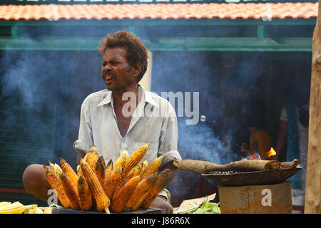 Eine Straße Verkäufer Verkauf von geröstetem Mais an einem heißen sonnigen Tag in den Straßen von Indien, seinen Lebensunterhalt zu verdienen Stockfoto