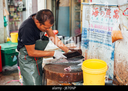 GEORGE TOWN, MALAYSIA - März 23: Mann bereiten die Fische zum Verkauf auf dem nassen Markt am 23. März 2016 in George Town, Malaysia. Stockfoto