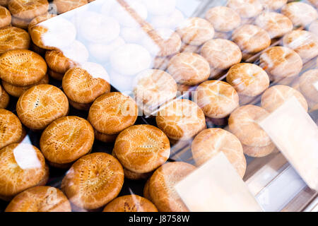 der Verkäufer erhält eine Hand Kuchen. hausgemachte Scones Anzeige auf einem Platz. unter Glasvitrine. Straße auf dem Markt, Fast-Food Handel Stockfoto