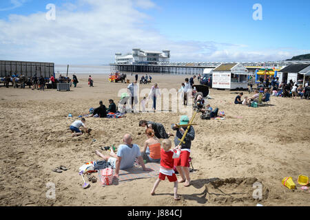 Menschen genießen das warme Wetter am Weston-super-Mare Strand, Briten, in der Hoffnung auf einen sengenden Feiertag enttäuscht sein mag, wie Meteorologen vorhersagen, dass Temperaturen startet am Samstag mit einer Chance von Regen und Gewitter während des langen Wochenendes fallen. Stockfoto