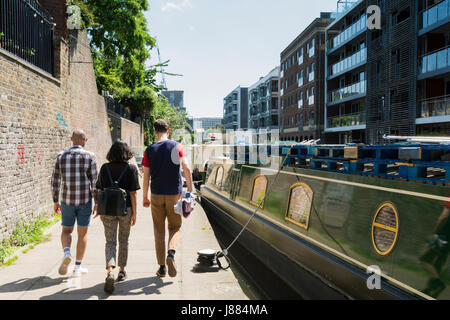 Menschen, die auf dem Treidelpfad neben dem Grand Union Canal in der Nähe von King's Cross in London, England, Großbritannien, wandern. Stockfoto