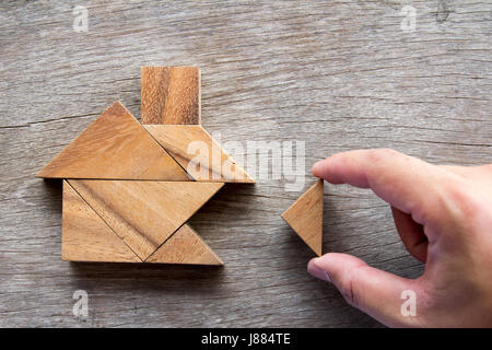 Hölzerne Tangram Puzzle warten zu Hause Form für Build Traum nach Hause oder glücklich Lebenskonzept zu erfüllen Stockfoto