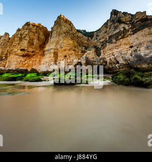 Grünen Steinen am Strand von Porto de Mos in Lagos, Algarve, Portugal Stockfoto