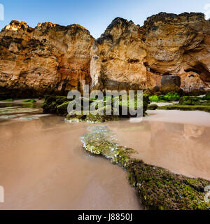 Grünen Steinen am Strand von Porto de Mos in Lagos, Algarve, Portugal Stockfoto