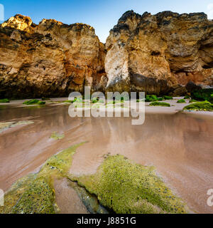 Grünen Steinen am Strand von Porto de Mos in Lagos, Algarve, Portugal Stockfoto