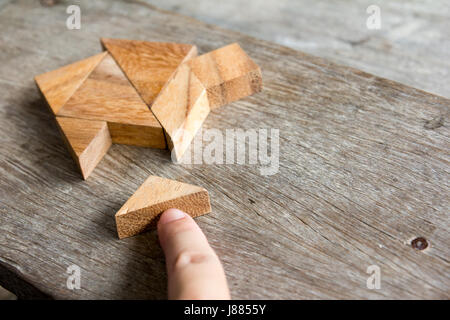 Hölzerne Tangram Puzzle warten zu Hause Form für Build Traum nach Hause oder glücklich Lebenskonzept zu erfüllen Stockfoto