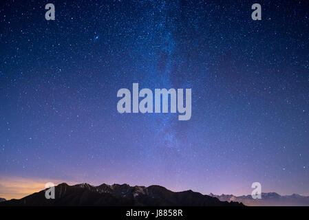 Die wunderbaren Sternenhimmel auf Weihnachten und die majestätische hohe Bergkette der Alpen Französisch, mit leuchtenden Dörfern unten und Mondschein. Stockfoto