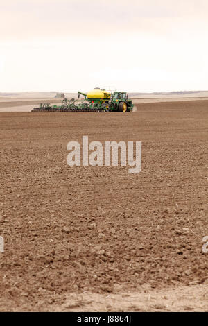 Ein Traktor pulling Landmaschinen, Weizen in den fruchtbaren Feldern des Idaho zu Pflanzen. Stockfoto