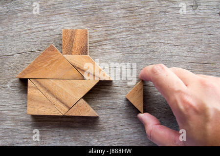 Hölzerne Tangram Puzzle warten zu Hause Form für Build Traum nach Hause oder glücklich Lebenskonzept zu erfüllen Stockfoto