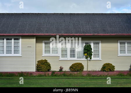 Seite Außenwand des Holzhaus mit verglasten Fenstern in Holzrahmen und Wetterschenkel Verkleidung und Welldach. Stockfoto
