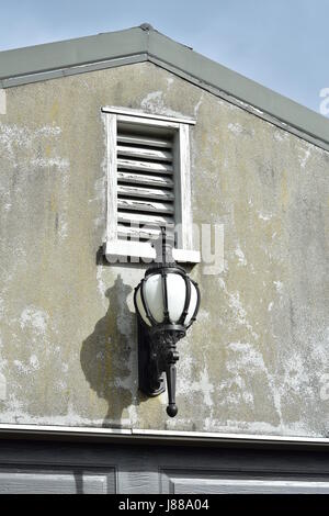 Vintage Gusseisen kugelige Form Lampe auf die Außenwand des verwitterten Haus. Stockfoto