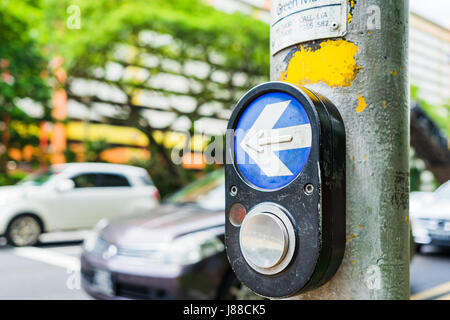 Taste für Ampel und Autos im Hintergrund. Ampel an der Kreuzung. Taste des Mechanismus leuchtet Ampeln auf der Straße. System Stockfoto