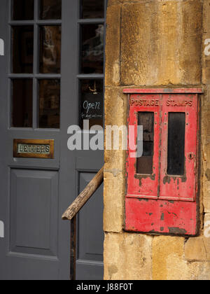 Alte Holztür lackiert grau (grau) und Antik distressed Briefkasten in Chipping Campden, Gloucestershire, England, UK Stockfoto