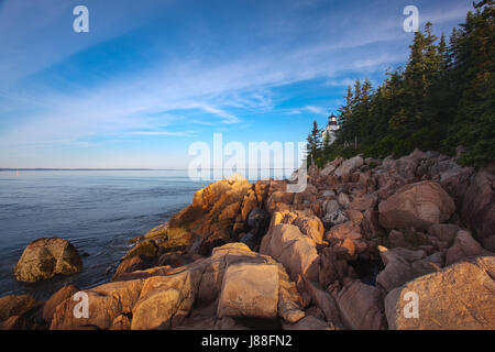 Sonnenaufgang auf felsigen Küste Maines am Bass Harbor Head Lighthouse im Acadia National Park auf Mount Desert Isle. Stockfoto