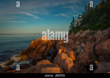 Sonnenaufgang auf felsigen Küste Maines am Bass Harbor Head Lighthouse im Acadia National Park auf Mount Desert Isle. Stockfoto